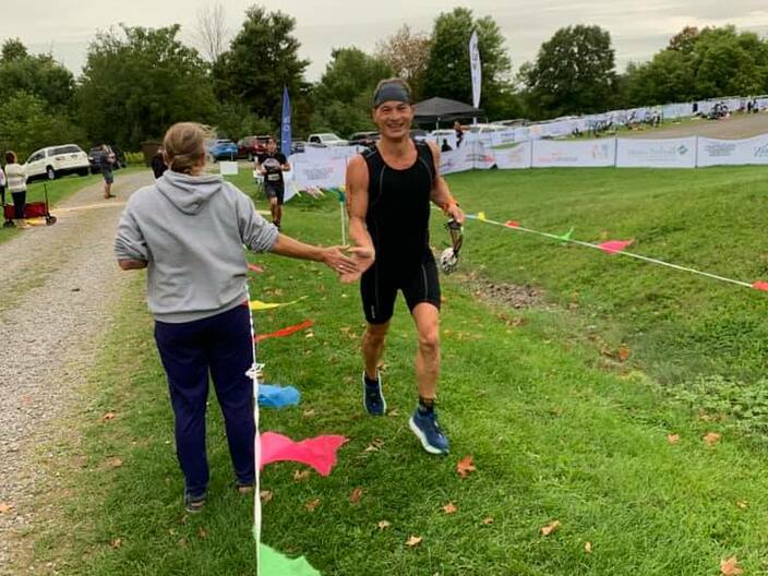 race director encouraging athletes at the beginning of the run, the last discipline